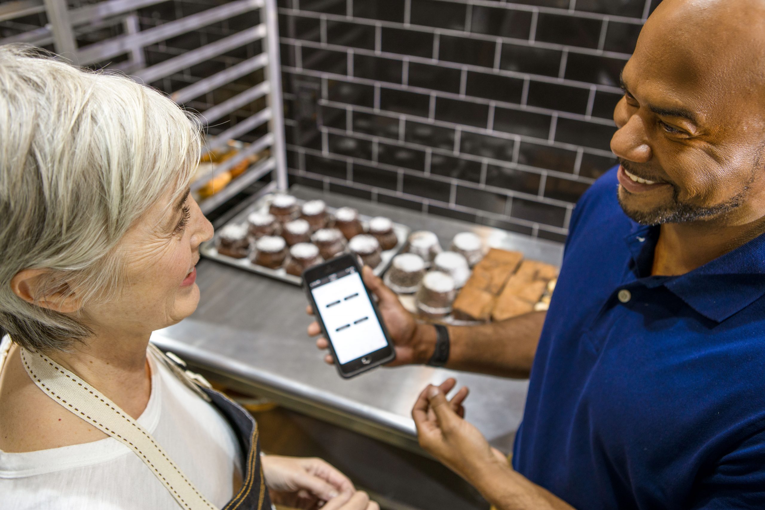 A small business owner looks at the Total Connect App to control her business security system.