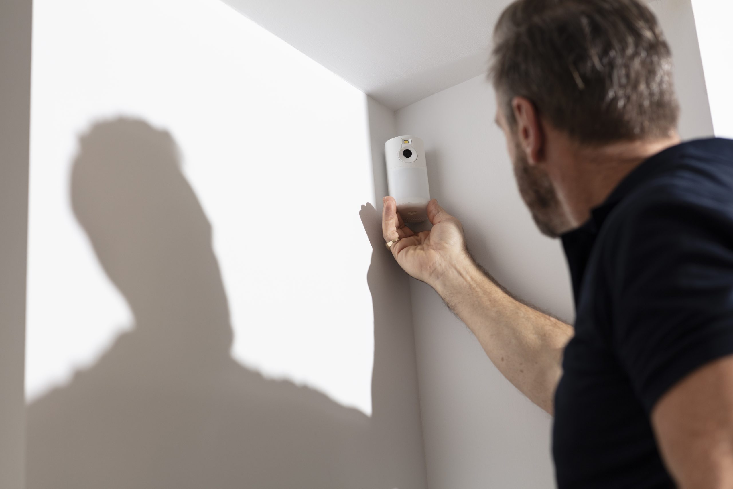 a man installing a motion detector 