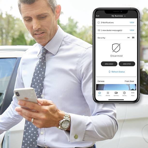 A business owner looks at the status of his security system on his mobile device in the Total Connect App