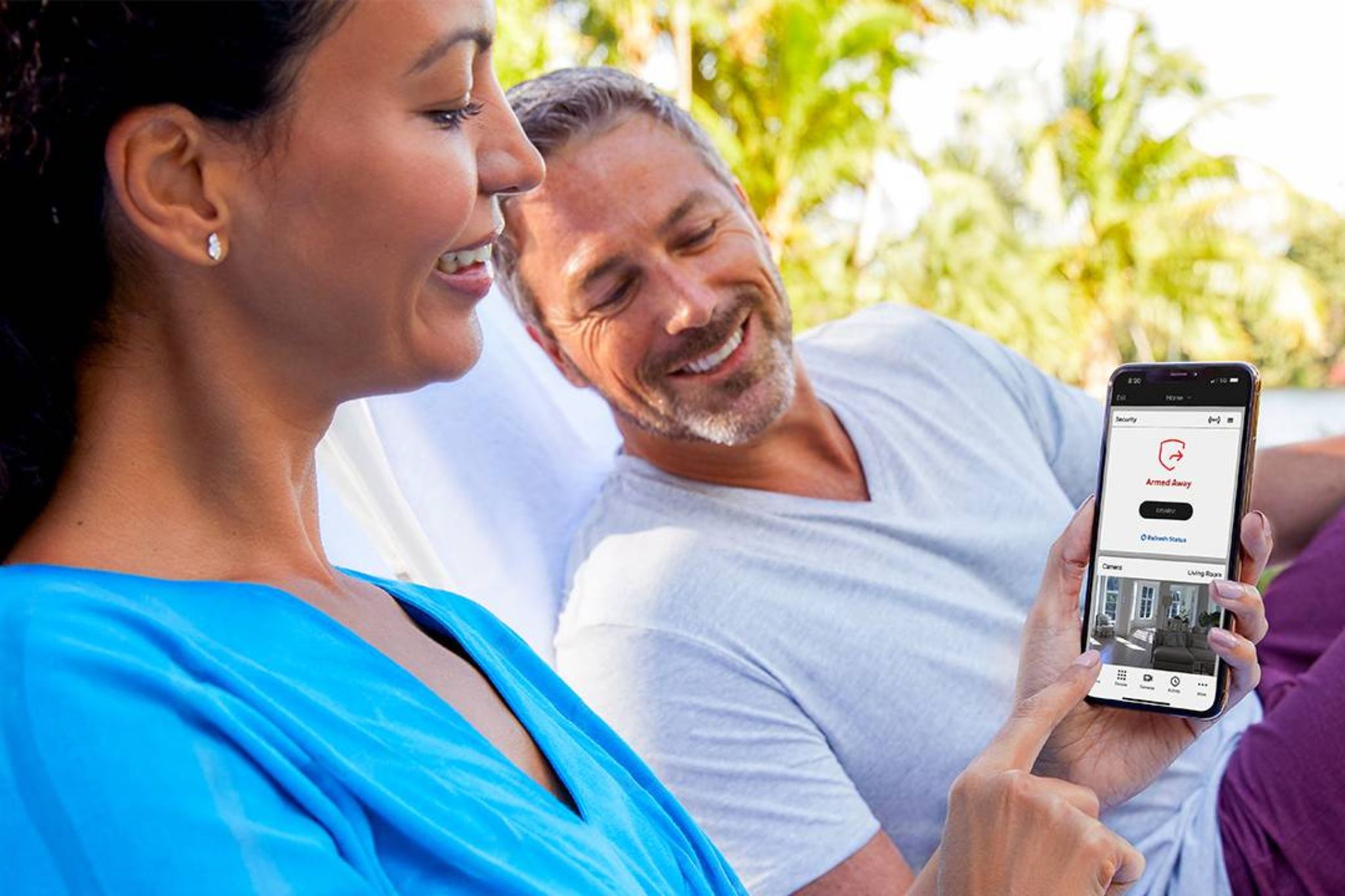 A couple view their home security system using remote access through the Total Connect App.