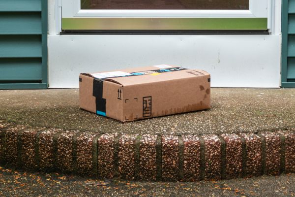 A package from online retailer, Amazon, sitting unattended on a porch. Prevent package theft.